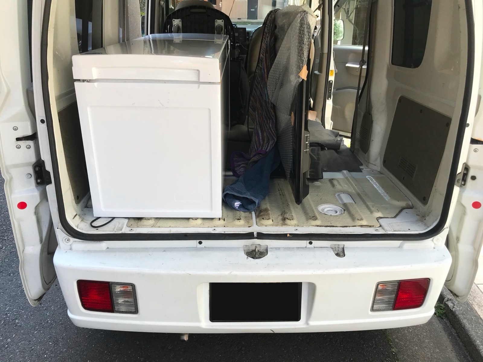 軽バンの荷台に冷蔵庫などを積み込んだ様子
